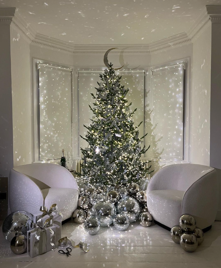Giant crescent moon shaped christmas tree topper on christmas tree 