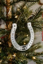 Load image into Gallery viewer, A horseshoe shaped ornament with the word Lucky hanging from a christmas tree.
