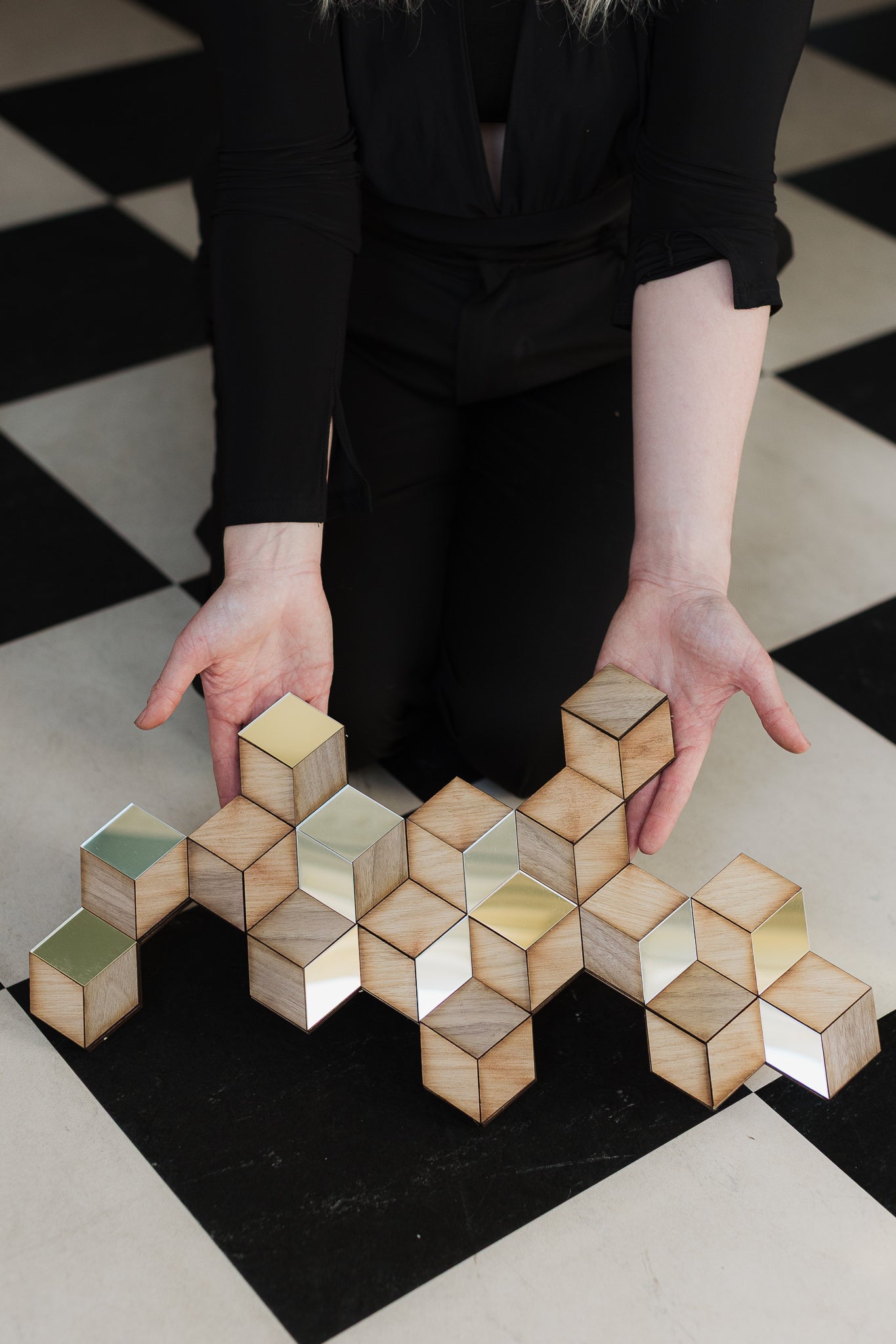 Rhombille tiling art decoration held against a checkered pattern floor