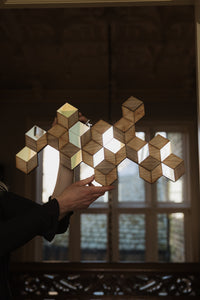 Handmade Rhombille tiling wall decoration held in a window catching the light
