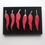 Load image into Gallery viewer, A photo taken from above of six chilli pepper shaped ornaments in a gift box.
