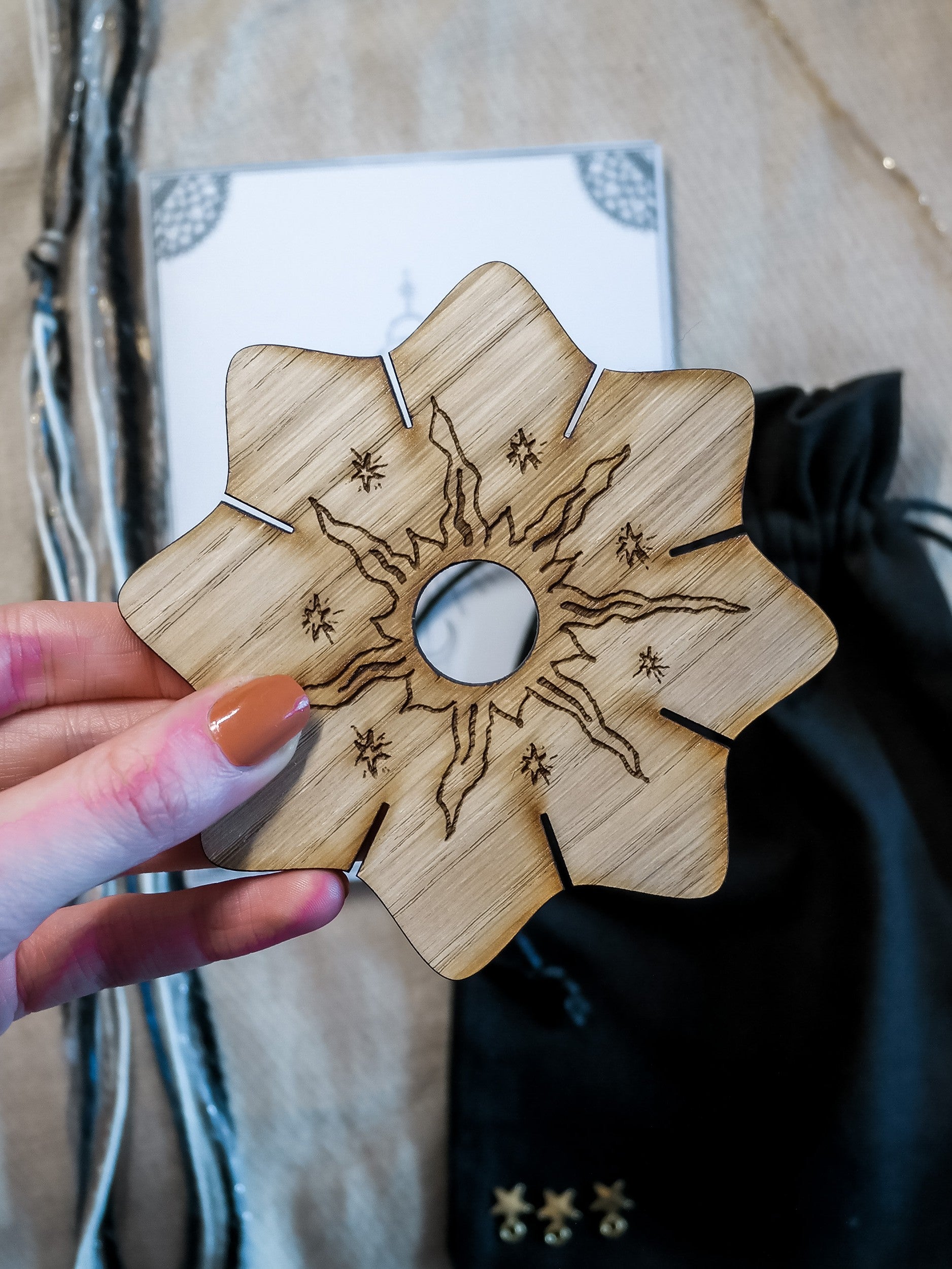 Wooden knitting circle engraved with a celestial sun design.