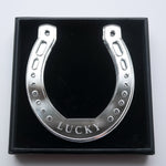 Load image into Gallery viewer, A silver horseshoe shaped ornament with the word lucky in a giftbox
