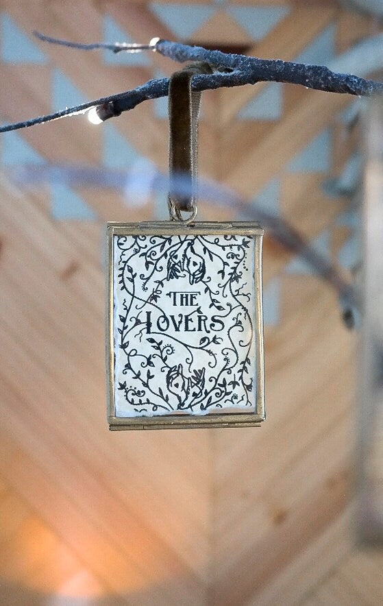 Square ornament with 'The Lovers' design on a branch