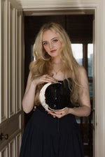 Load image into Gallery viewer, A gold crescent moon mirror held in the hands of a blonde woman
