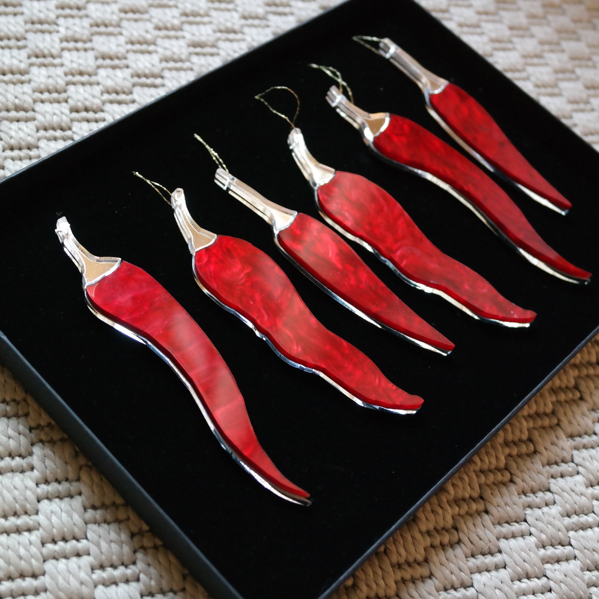 Six chilli pepper shaped ornaments in a gift box.