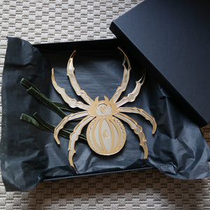 A gold and silver spider shaped mirror