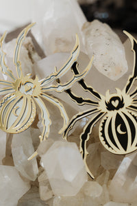 2 spider shaped mirrors laying on a bed of crystals