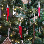 Load image into Gallery viewer, three chilli pepper shaped ornaments hanging in a christmas tree.
