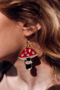 A red, white and silver toadstool shaped earring with acrylic and mirror.