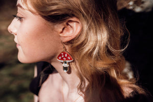 A red, white and silver toadstool shaped earring with acrylic and mirror.