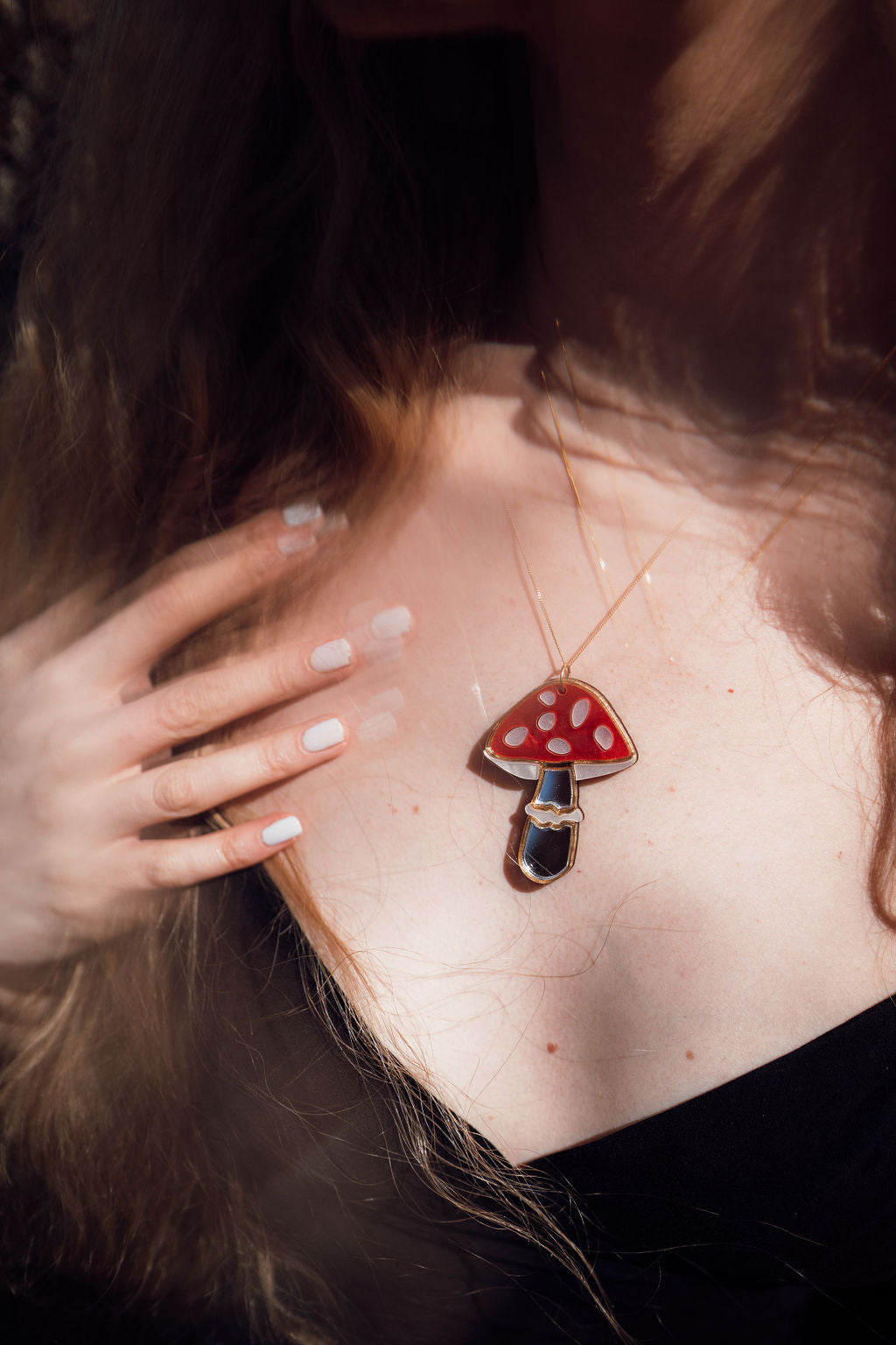 A red, white and silver toadstool shaped necklace with acrylic and mirror.