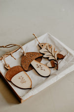 Load image into Gallery viewer, 3 woodland themed decorations in the shape of a leaf, acorn and toadstool handmade from wood in a gift box.
