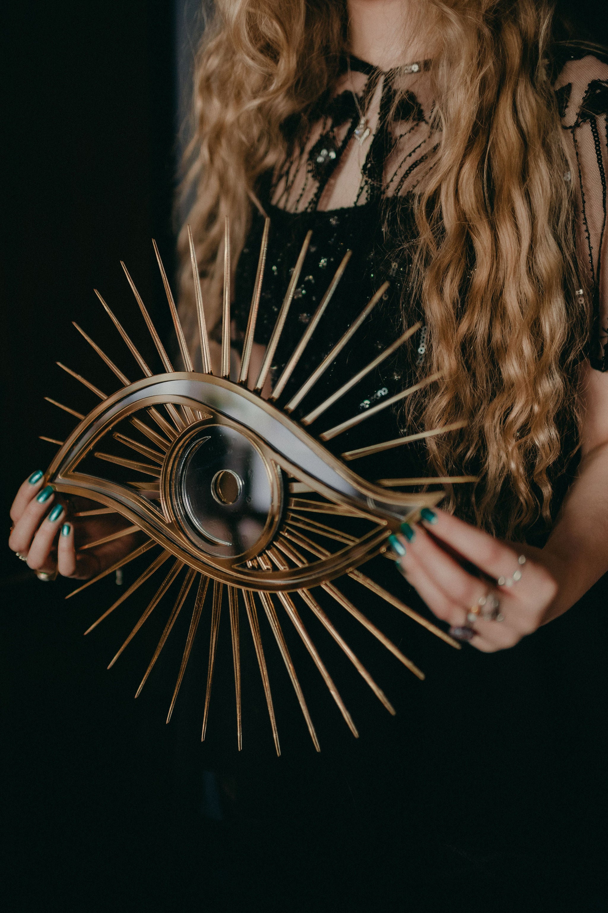 hands holding All seeing eye shaped mirror.