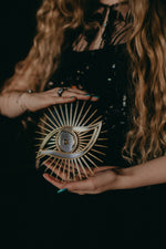 Load image into Gallery viewer, All seeing eye shaped christmas tree topper held in hands.
