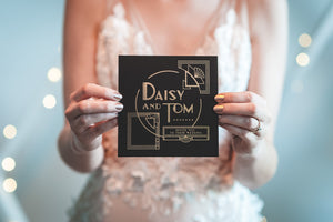 bride holding art deco inspired wedding invitation