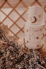 Load image into Gallery viewer, A white cake with golden stars and moon cake charms

