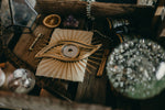 Load image into Gallery viewer, All seeing eye shaped christmas tree topper laying flat in box.
