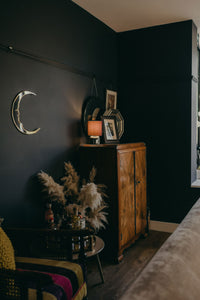 crescent moon shaped mirror on the wall of a home.