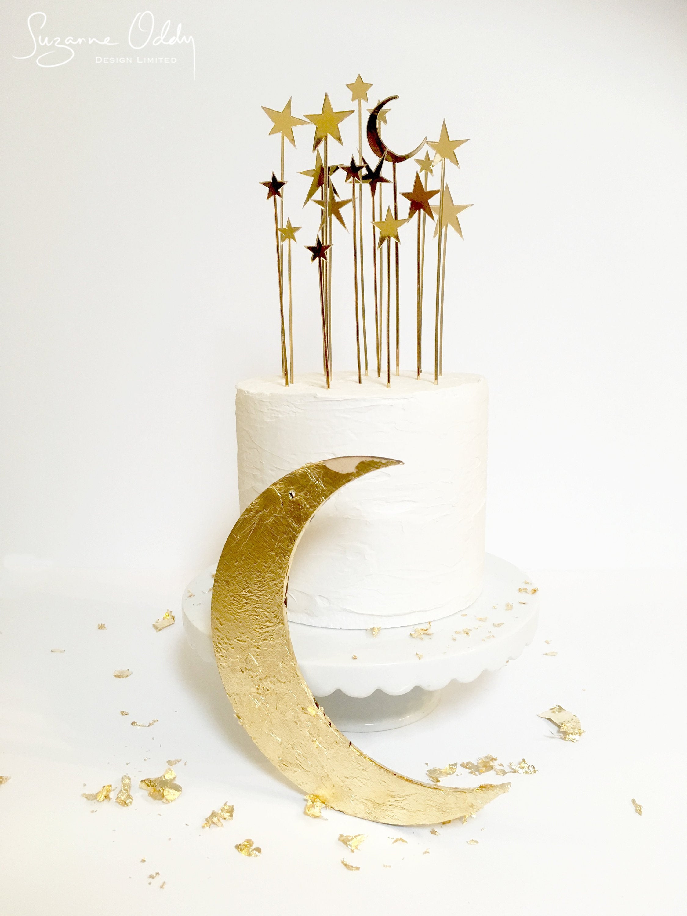 A birthday cake with crescent moon and star shower cake topper.