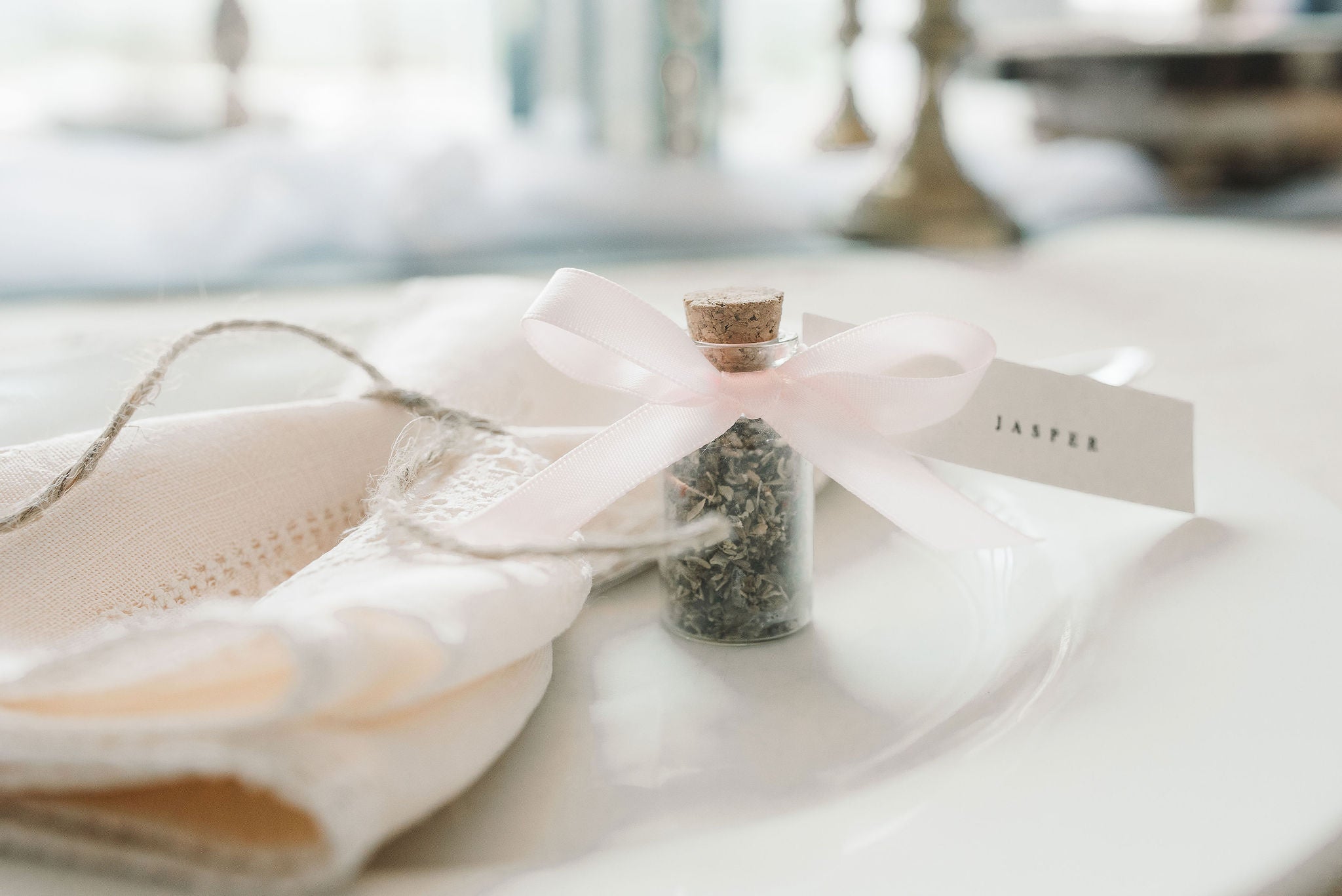 Wedding place name printed on pink bow attached to jar.