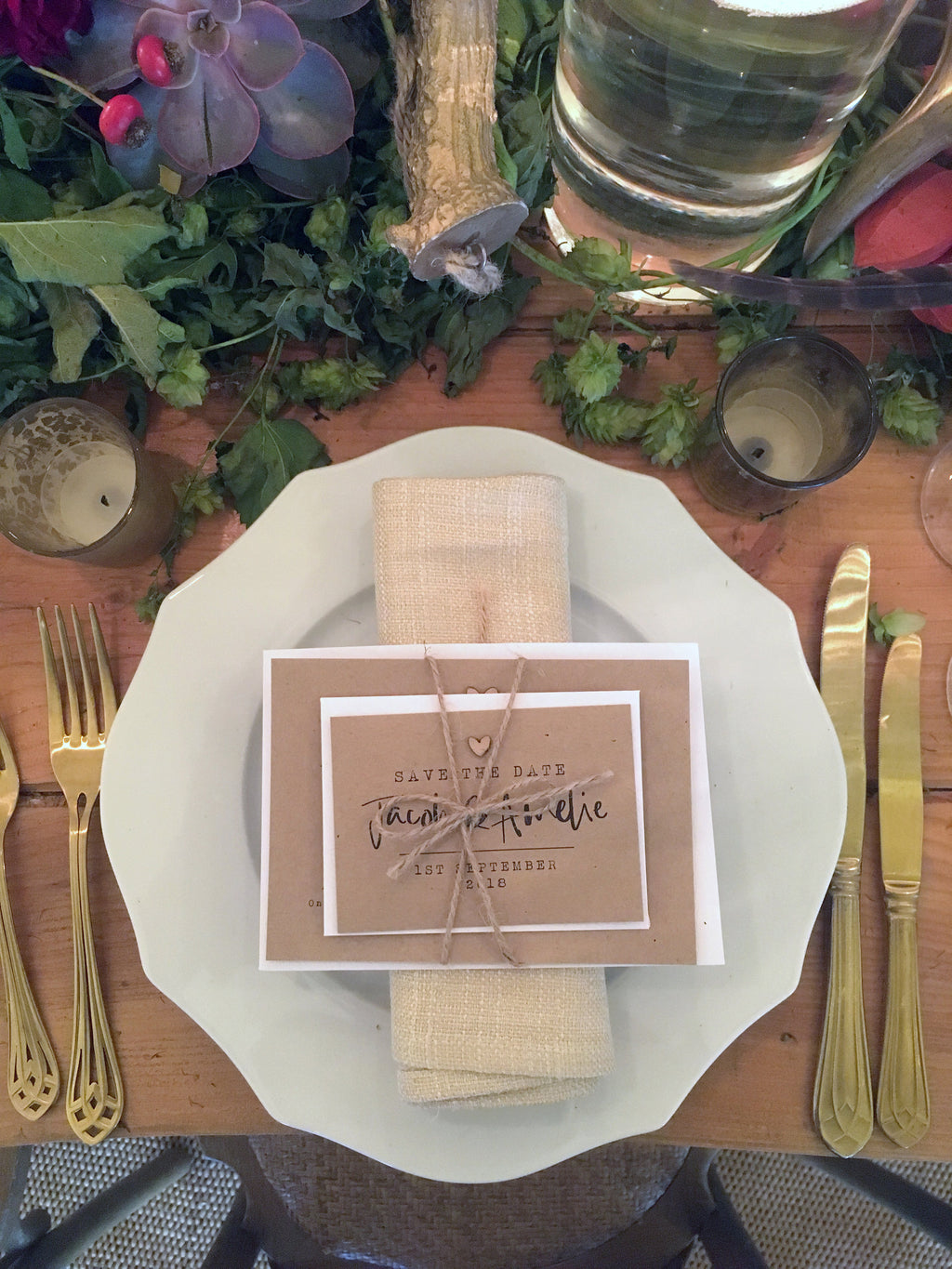 Brown and white paper wedding invitations on a place setting