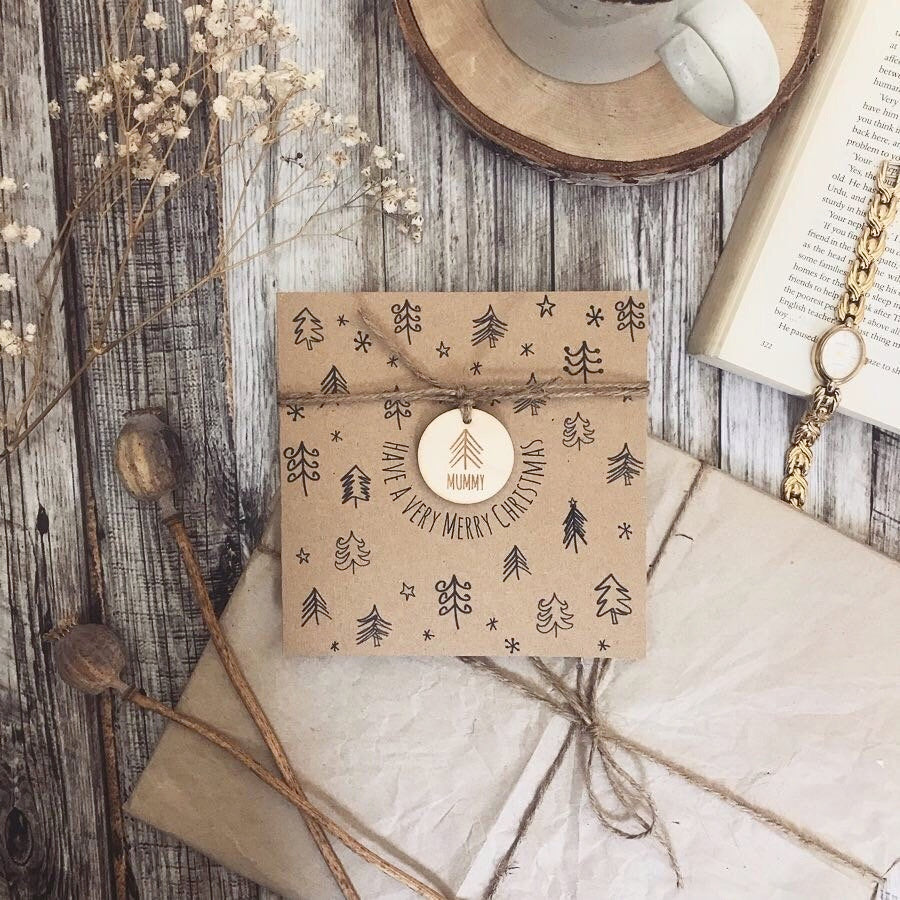 Kraft board christmas card with engraved wooden ornament tied with string