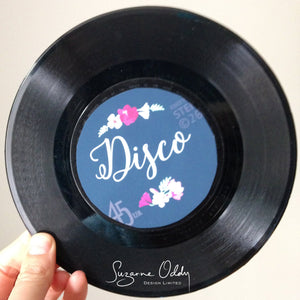 A wedding invitation shaped like a record with the word disco.