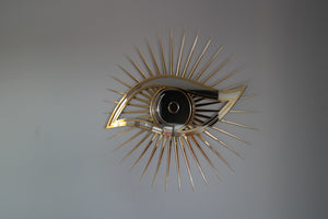 All seeing eye shaped mirror with gold and silver.