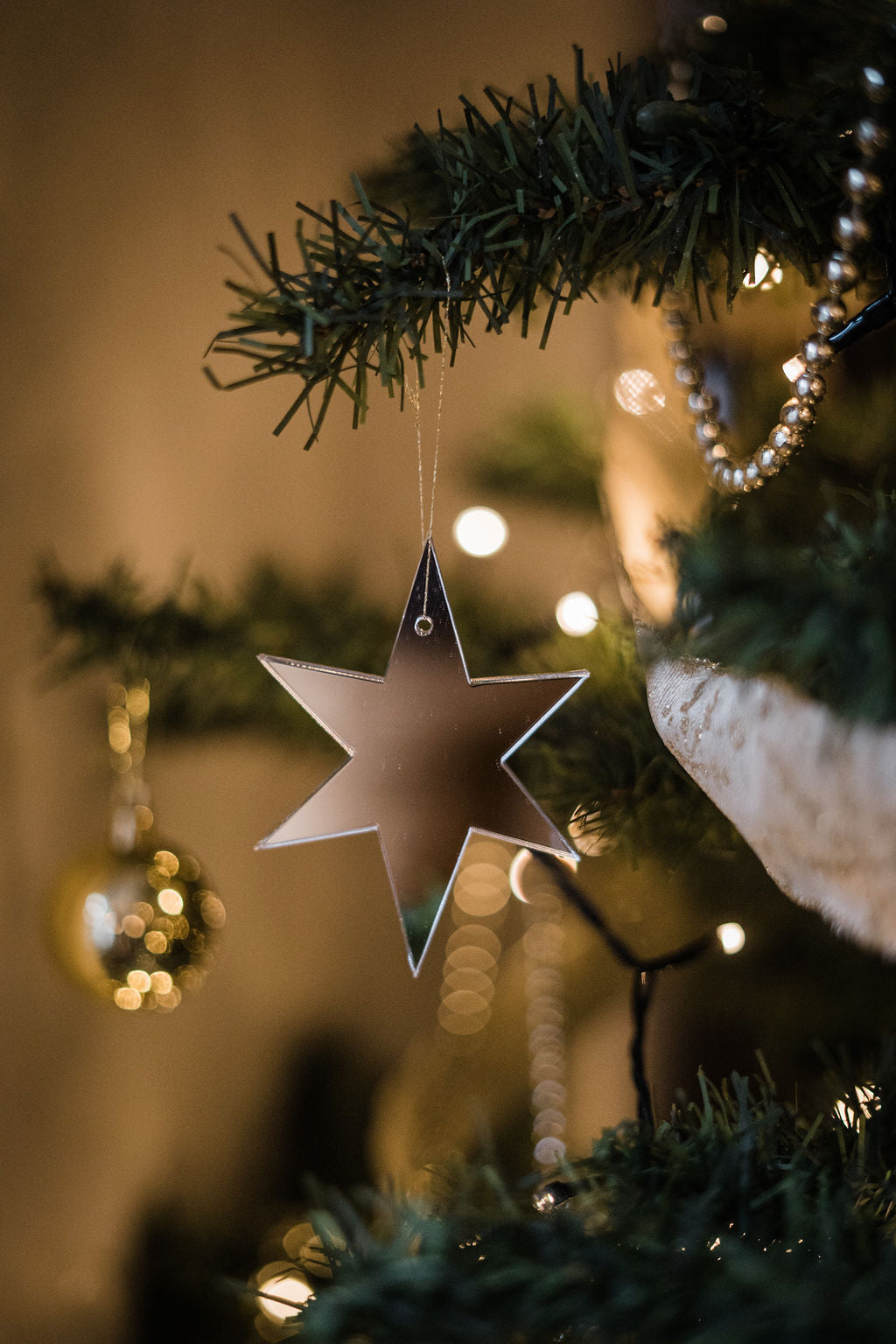 star shaped mirror christmas ornament hanging from tree