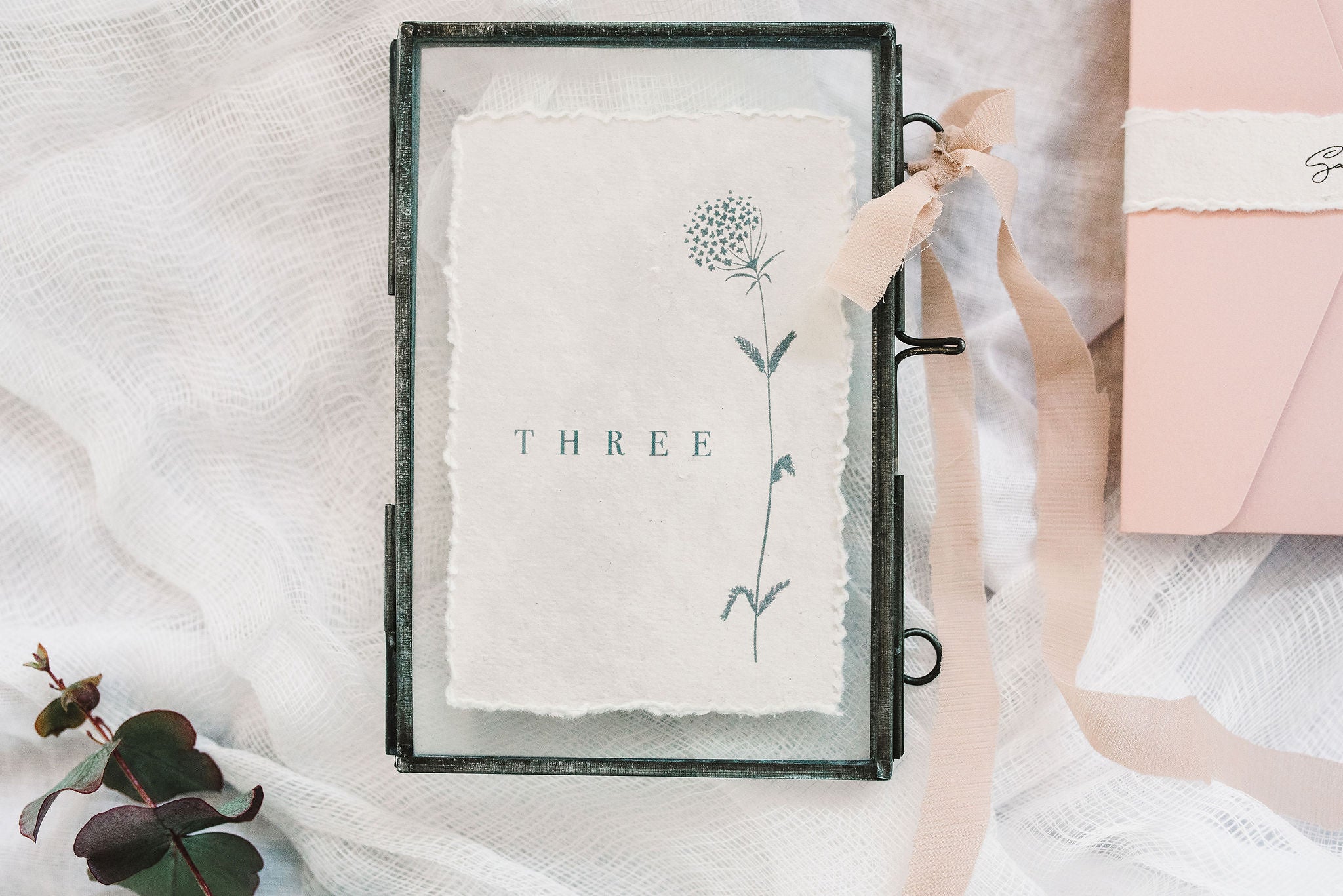  handmade rag paper table number with floral design in frame with bow