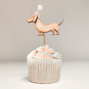 A sausage dog shaped cupcake topper on a cupcake