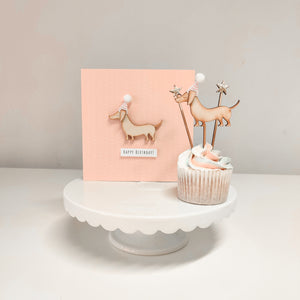 A wooden sausage dog cupcake topper and birthday cake 