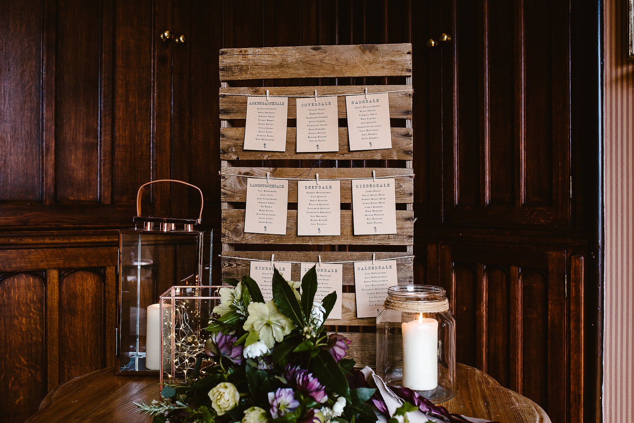 Brown floral seating plan cards attached to board with pegs