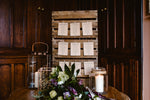 Load image into Gallery viewer, Brown floral seating plan cards attached to board with pegs
