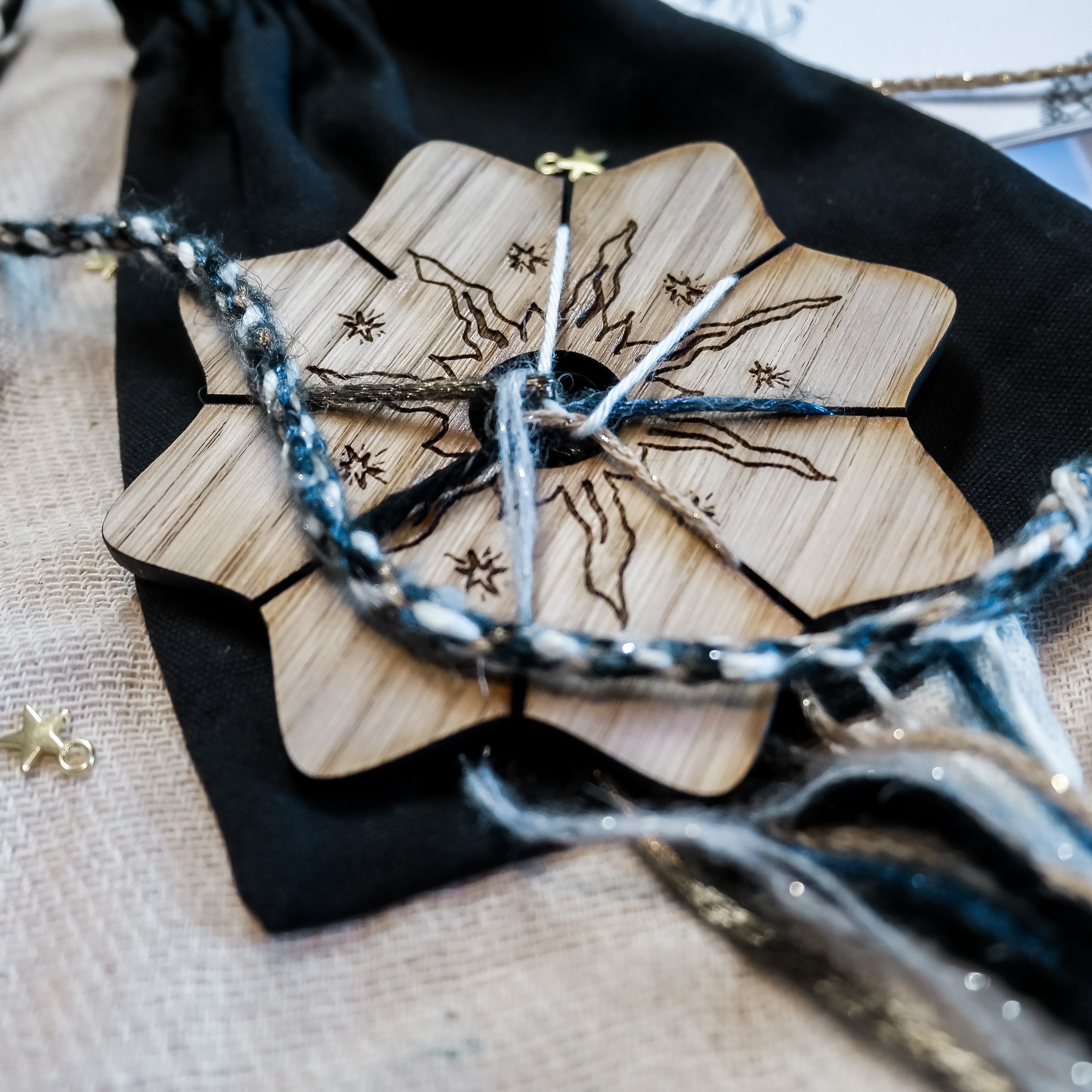 Wooden knitting circle engraved with a celestial sun design with wool and keepsake velvet bag.