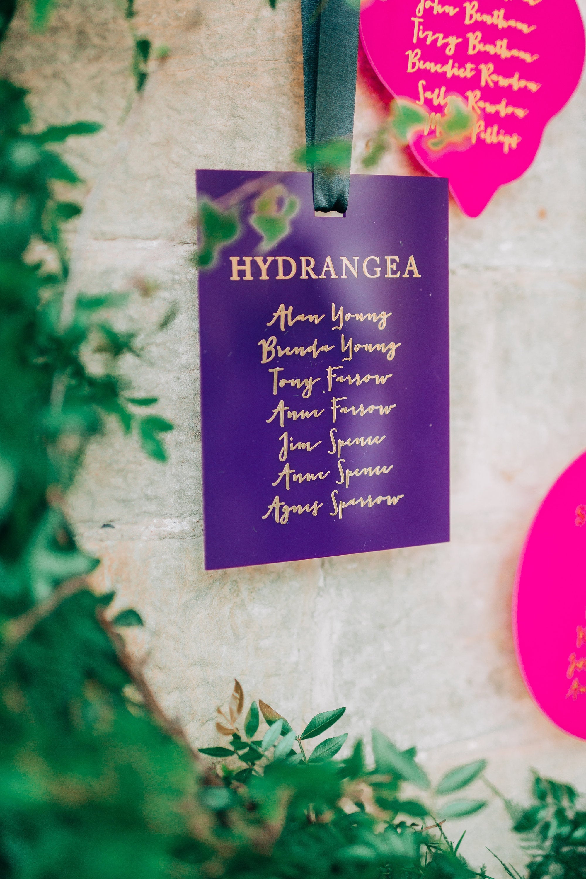 A purple hanging seating plan display for a wedding