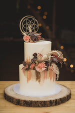Load image into Gallery viewer, Sacred Geometry wooden cake topper with flowers on tree stump
