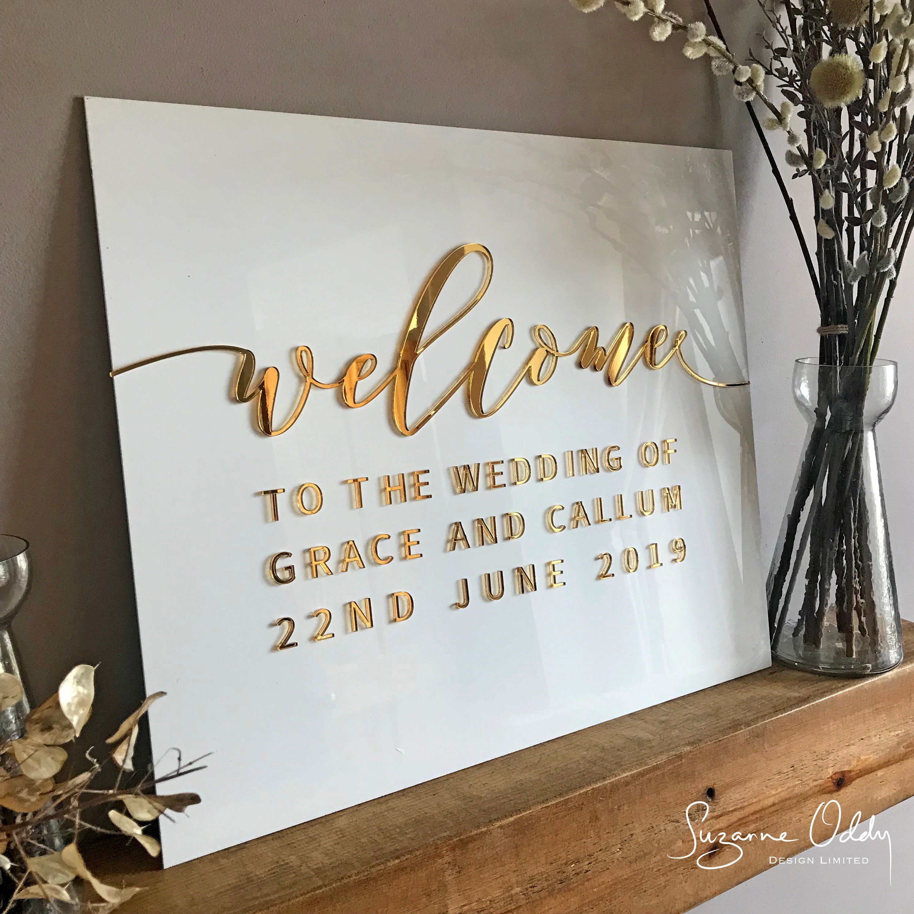 White acrylic wedding sign with welcome to the wedding in gold
